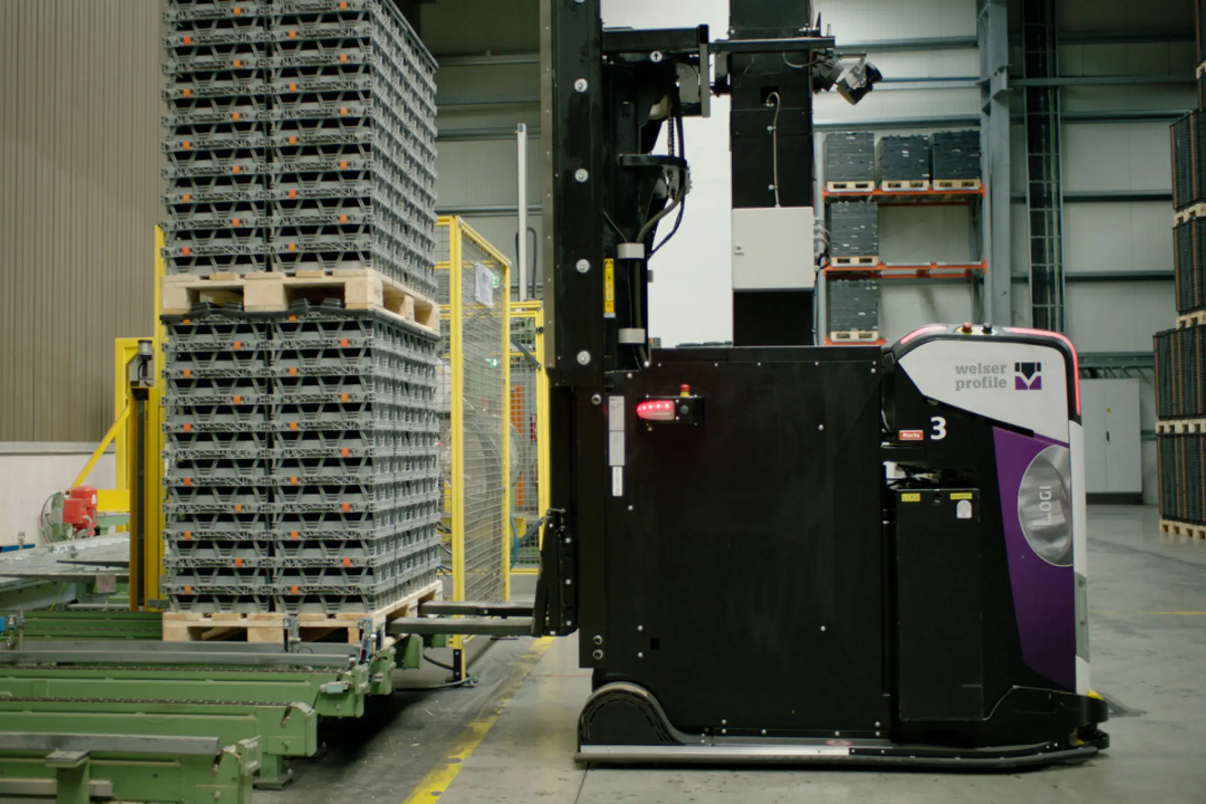 AGV Logisnext transportant des palettes dans un environnement industriel.