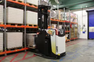 AGV Logisnext assurant le transport automatisé de charges dans un entrepôt logistique.