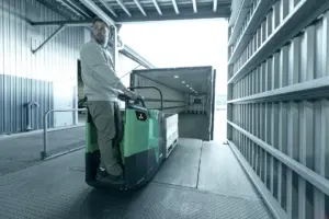 transpalette à conducteur porté sur plateforma benhur déchargeant un camion.