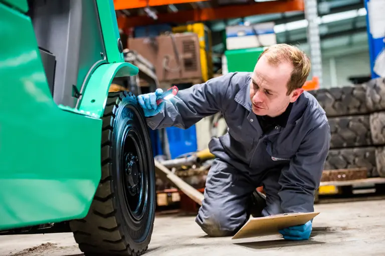 technicien effectuant la maintenance et la vérification d'un chariot élévateur