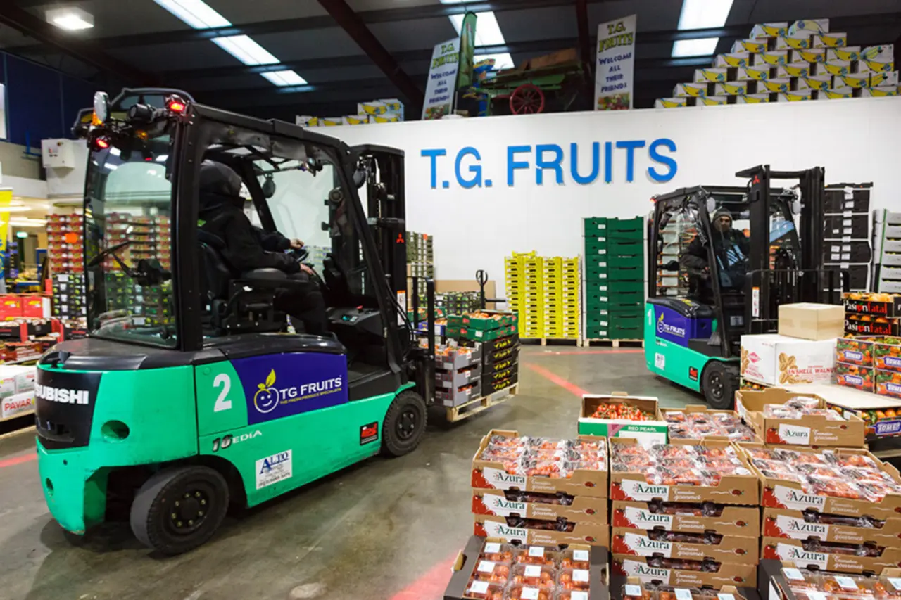 Chariot élévateur électrique Logisnext transportant des produits conditionnés dans un environnement de distribution de fruits et légumes.
